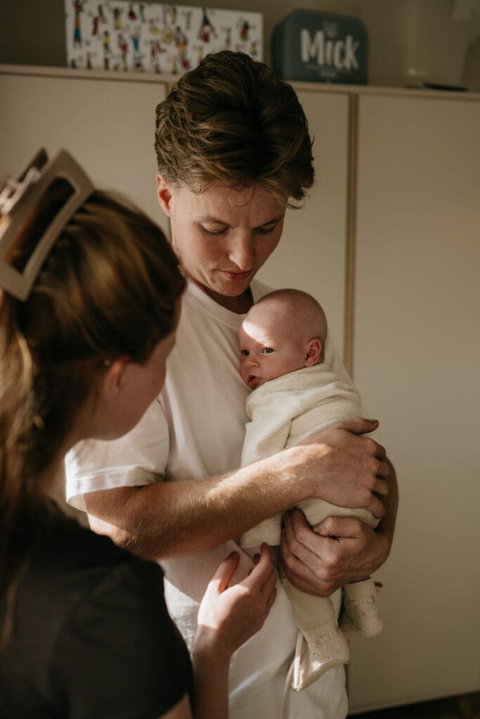 Puur gezinsleven gevangen: papa troost liefdevol een huilende baby tijdens een fotoreportage aan huis.
