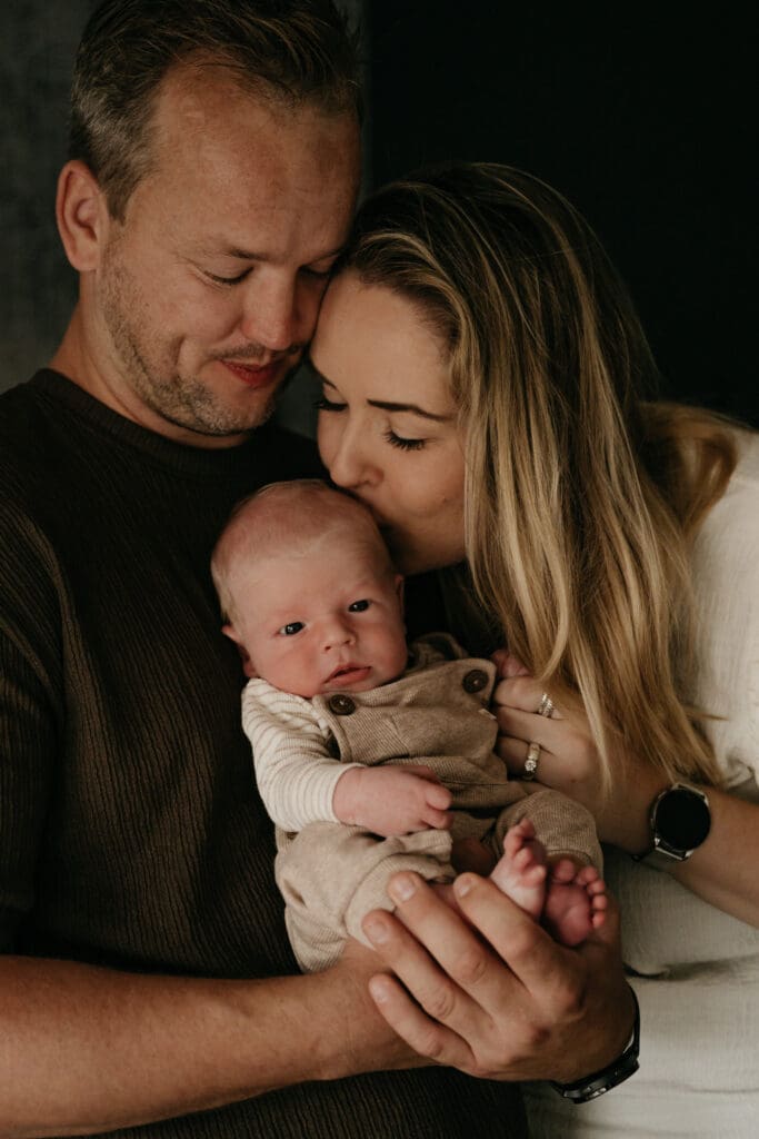 Puur en onbewaakt moment van gezinsknuffel met een newborn baby vastgelegd door documentaire fotograaf Brechje Verhoeven.